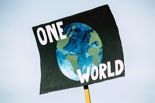 A poster showing planet Earth on a black background with words One World